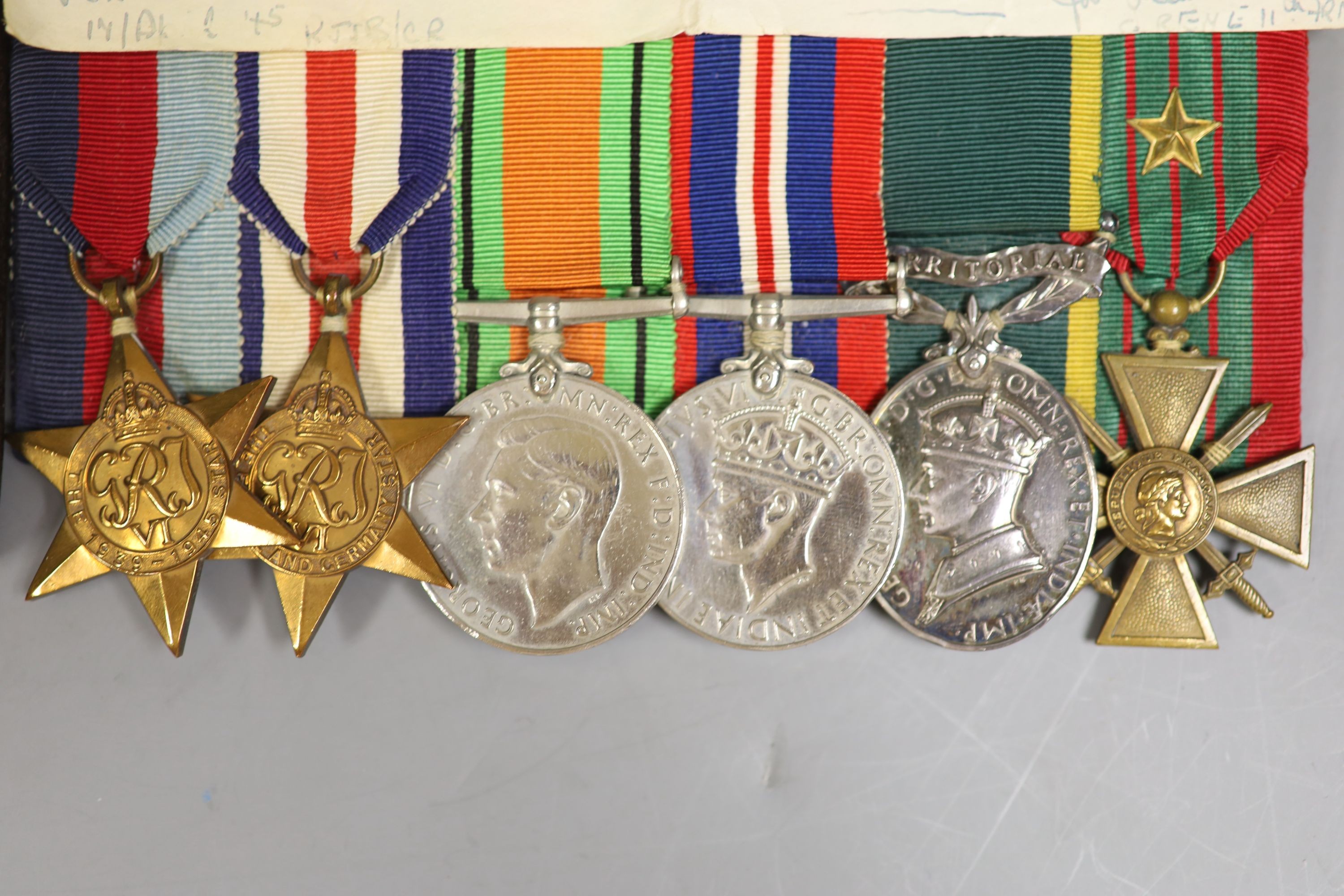 A group of WWII medals and a cased miniature group of medals, probably to War Subs. Maj J K Carson 160470, HQ REME with letter stating that the Croix de Guerre is awarded to officers of 11th Army Division